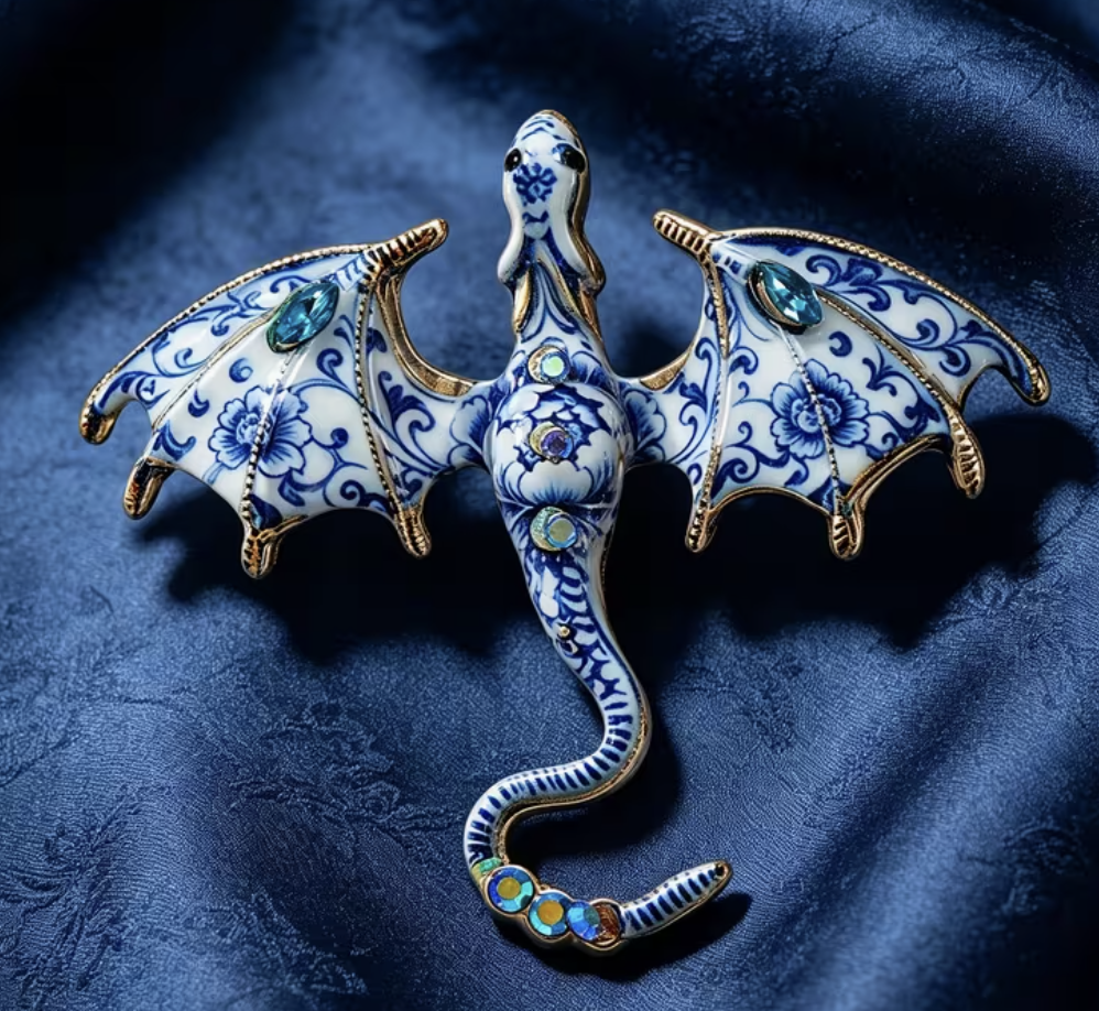 Blue and white porcelain dragon brooch with gold edging and blue gems