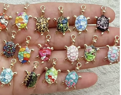 Row of small colourful enamel turtle charms in gold settings