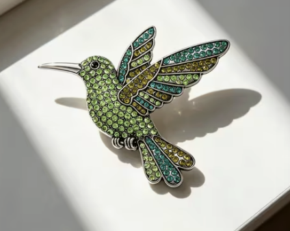 Green and yellow crystal hummingbird brooch in silver setting